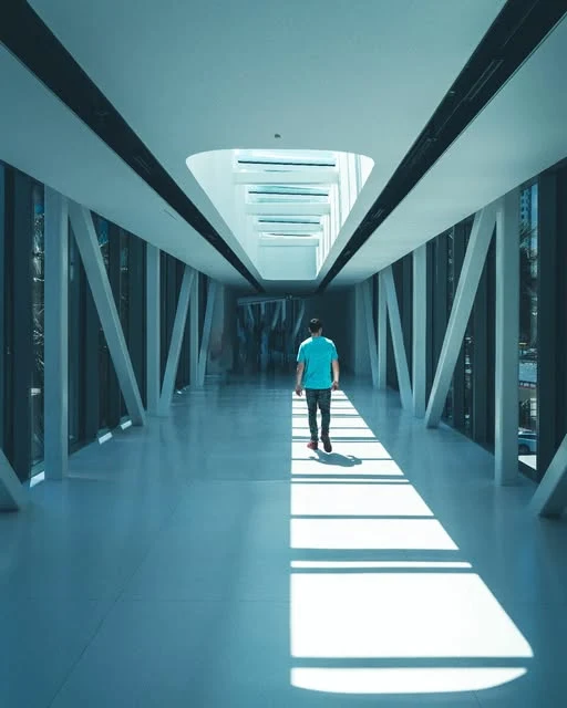Traveller walking through a modern sunlit architectural corridor