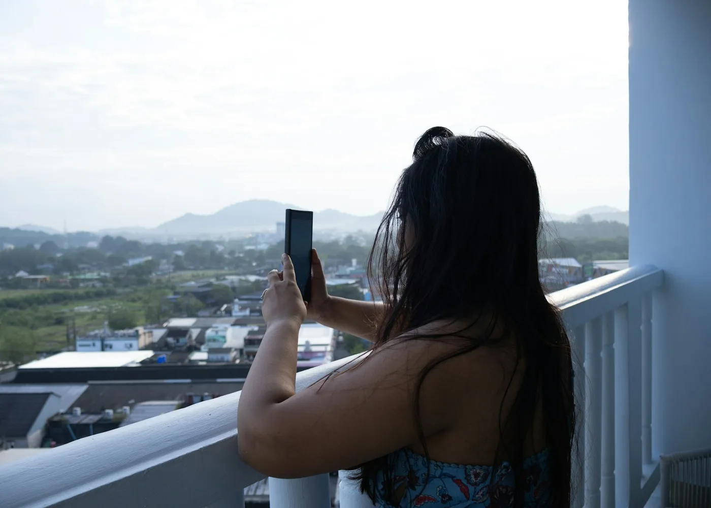 Traveller creating phone content from a hotel balcony